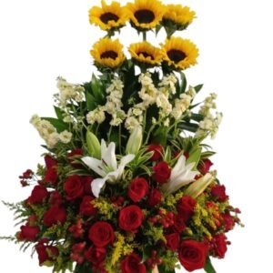 Arreglo floral tradicional alto en base de madera con girasoles rosas rojas y lirios cali