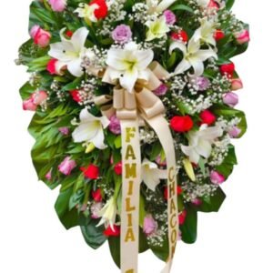 Corona fúnebre en pedestal con rosas de colores variados y lirios blancos cali